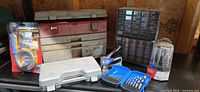 Overall view of lot showing toolbox, organizer cabinet, packaged Drill Snake, staple gun, drill bit set and cases