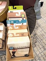 Assorted TheraFirm and Core-Spun compression hosiery boxes in cardboard display