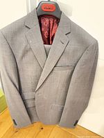 Front view of grey Ted Baker jacket with trousers folded underneath