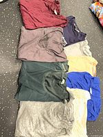Eight folded T-shirts in various colours