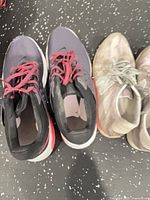 Purple/black Nike runners next to New Balance pair