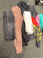 Workout pants and tops laid out on floor