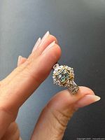 Front view of sterling silver ring with emerald and gold overlay detailing