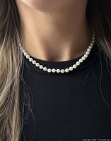 Pearl necklace worn on neck to show length and appearance