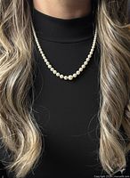 Pearl necklace worn on model showing length and graduation