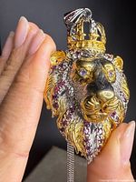 Front view of lion pendant showing gold overlay, garnets, crown