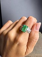Ring on hand showing emerald and band detail