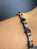 Bracelet worn on wrist showing design of sapphire and diamond links