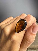 Ring worn on hand showing size and stone