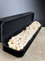 Pearl necklace laid in black velvet box