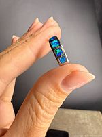 Close-up side view of sterling silver ring showing three square opal inlays