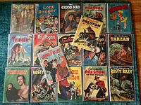 Overall layout of all fifteen comics in bags on teal surface