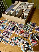 Five-row box filled with upright baseball cards; loose cards spread to show variety