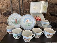 Front view showing two dessert plates, multiple cups and saucers with boxes