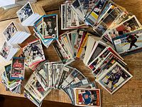 Overview of stacks and fanned assortments of hockey trading cards and stickers on tabletop