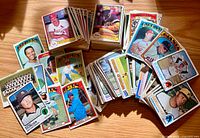 Wide view of multiple stacks and spread of vintage baseball cards showing various teams and players