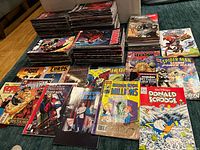 Overall view of assorted comic books laid out in piles and stacks