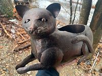 Full view of cat-shaped metal planter held in hand