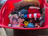 Red bin showing assortment including Madden NFL 08 game, wicker basket and toys