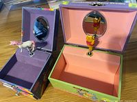 Both boxes open showing interiors, mirrors, rotating figures