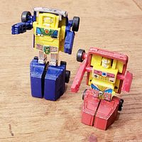 Two Gobots in robot mode standing on wooden surface