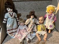 Group of five dolls on staircase showing size and outfits