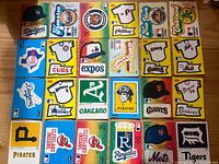 25 square Fleer MLB logo stickers laid out 5×5 on table
