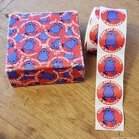 Sticker roll beside printed box showing graphics and quantity