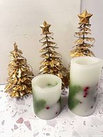 Group shot showing two flameless candles and three gold metal trees