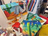 Group view of multiple printed pillow covers showing cactus scenes, sombrero figure, dancer and serape stripe designs