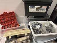 Overall lot with ammo box stack, driver bit case, first aid case, white bin and bagged parts