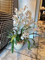 Full view of the faux orchid arrangement in its ceramic pot