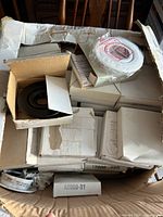 Open top of box showing numerous smaller cartons, visible black trim ring and wrapped module