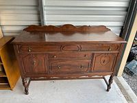Front view of wooden buffet showing doors, drawers, legs, backsplash