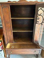 China cabinet open showing shelves and drawer