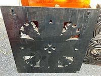 Back view of one carved wooden panel showing cut-outs and keyhole hangers