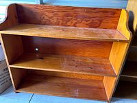 Front view of shorter three-shelf unit showing finish and cable hole