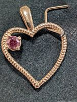 Heart-shaped 14K gold pendant with pink stone front view