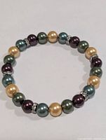 Full view of multicolour dyed pearl stretch bracelet showing bead colours and spacers