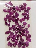 Loose pear-shaped rubies on tape, overview