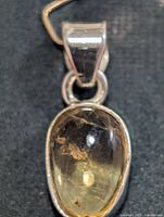 Front view of oval citrine pendant in silver setting