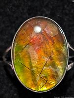 Front view of ring showing oval ammolite stone and colour play