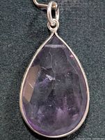Front view of teardrop faceted amethyst in silver bezel