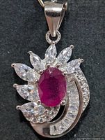 Front view of silver pendant with ruby and CZ stones