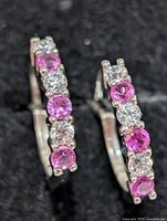 front view of earrings showing alternating pink and clear stones