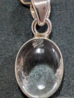 Front view of silver pendant showing oval quartz stone and bail