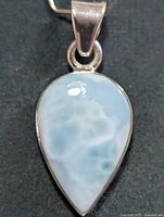 Front view of teardrop larimar pendant in silver setting