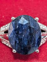Front view of ring showing oval blue stone and prong setting