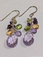 Front view of both earrings showing amethyst drops and gemstone cluster
