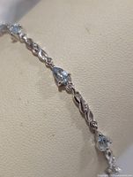 Close-up of bracelet section showing blue topaz and link design